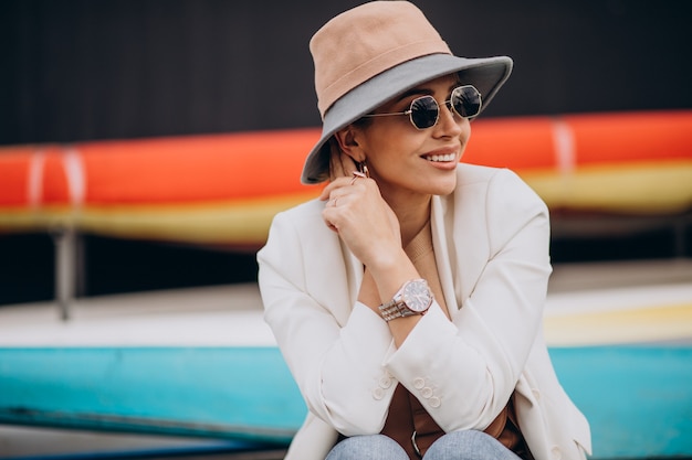 Mujer con sombrero sonriendo y usando teléfono