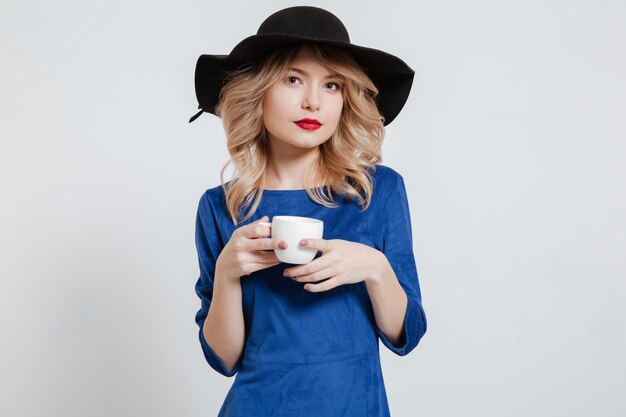 Mujer con sombrero con taza de café