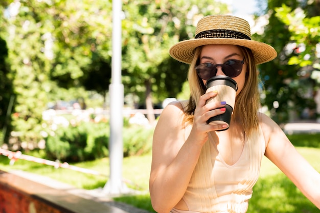 Foto gratuita mujer con sombrero tomando café