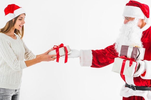 Mujer en sombrero tomando caja de regalo en santa claus