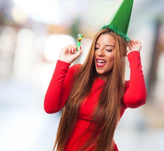 Mujer con un sombrero verde bailando y sonriendo