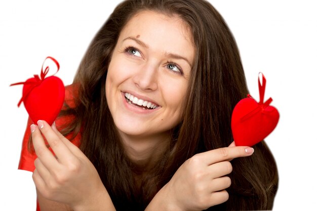 Mujer soñadora enseñando dos corazones