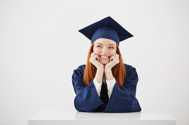 Mujer soñadora feliz graduado pensando soñando sonriente sentado.