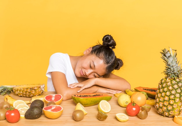 Foto gratuita mujer soñadora rodeada de frutas