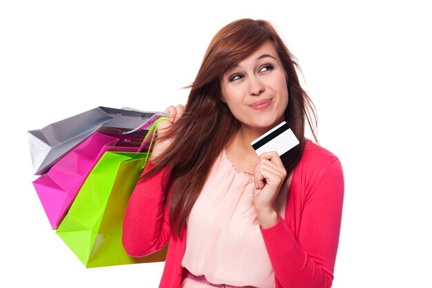 Mujer soñando con bolsas de compras y tarjeta de crédito