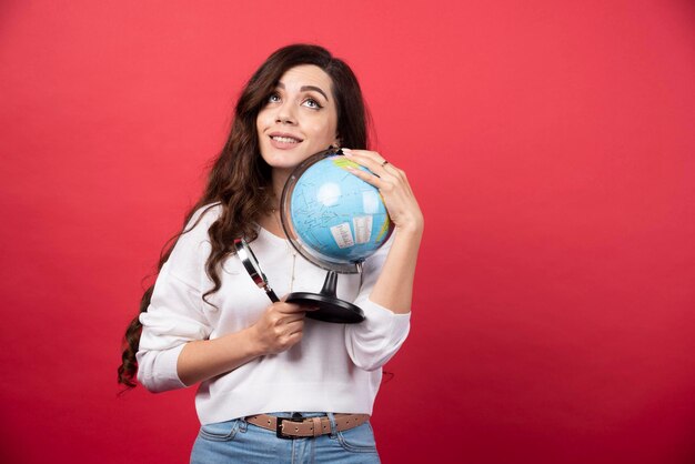 Mujer soñando con globo y lupa firmemente. Foto de alta calidad