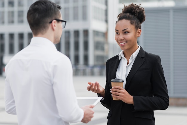 Mujer sonriendo al compañero de trabajo tiro medio