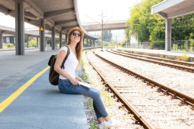 Foto gratuita mujer sonriendo y buscando el tren