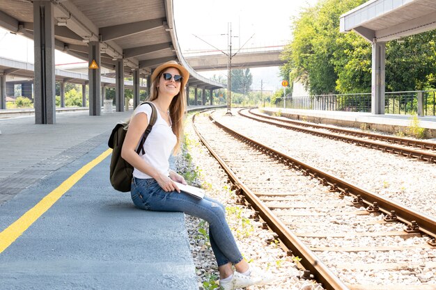 Mujer sonriendo y buscando el tren