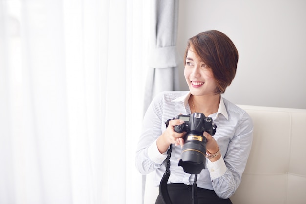 Mujer sonriendo con una cámara reflex