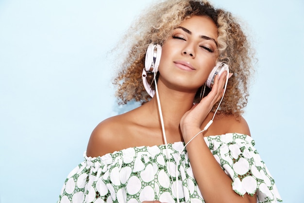 mujer sonriendo y escuchando música en auriculares