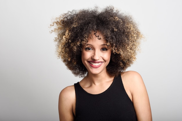 Mujer sonriendo de frente con el pelo rizado