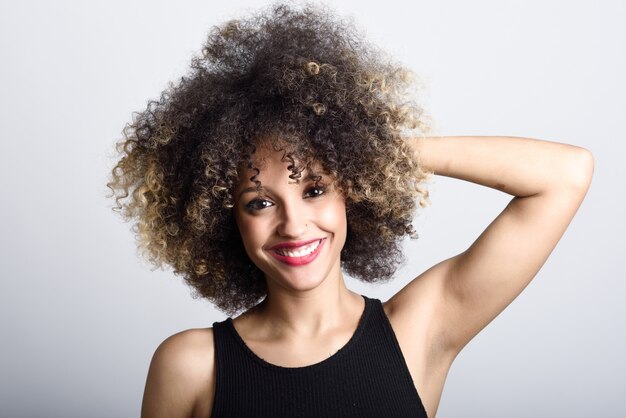 Mujer sonriendo de frente con el pelo rizado