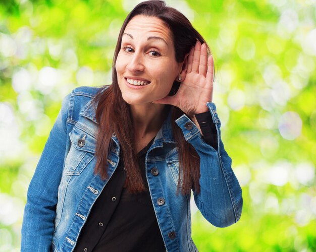 Mujer sonriendo con una mano en la oreja