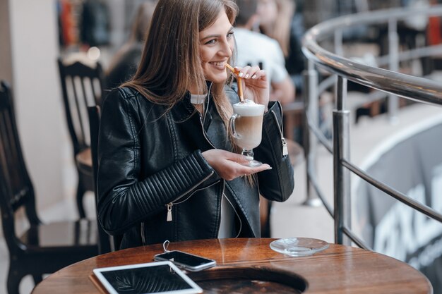 Mujer sonriendo mientras bebe un batido