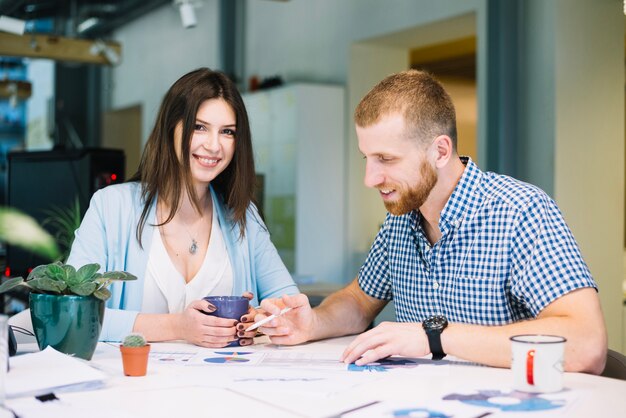 Mujer sonriendo mientras trabajaba con hombre