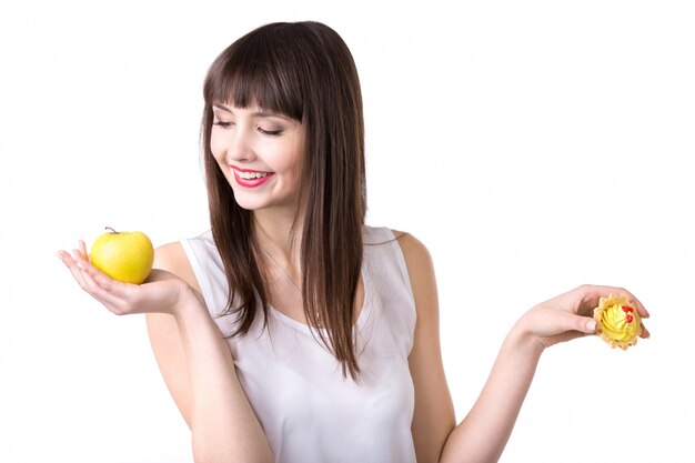 Mujer sonriendo mirando una manzana
