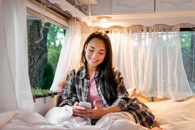 Mujer sonriendo y mirando en su teléfono inteligente