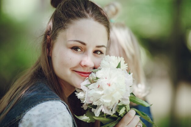 Mujer sonriendo con un ramo de flores blancas