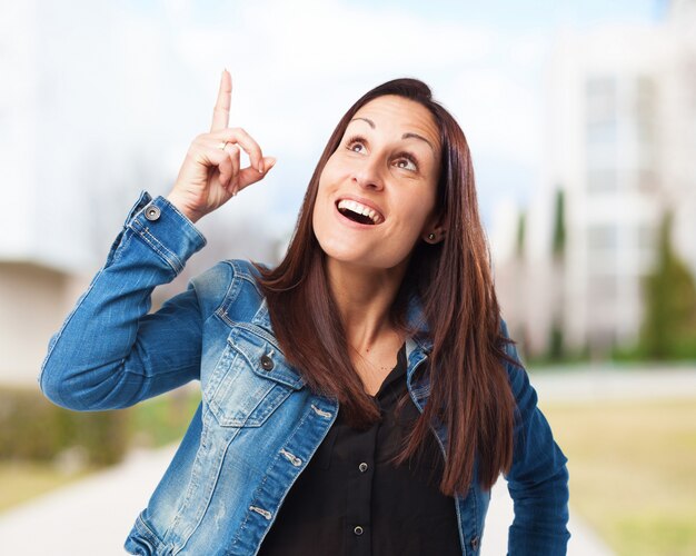 Mujer sonriendo señalando al cielo