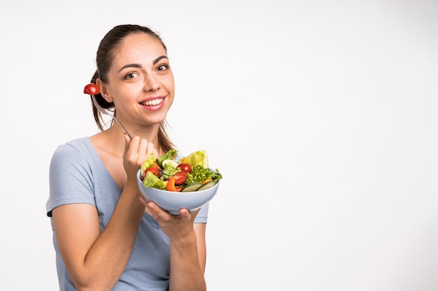 Mujer sonriendo y sosteniendo un espacio de copia de ensalada