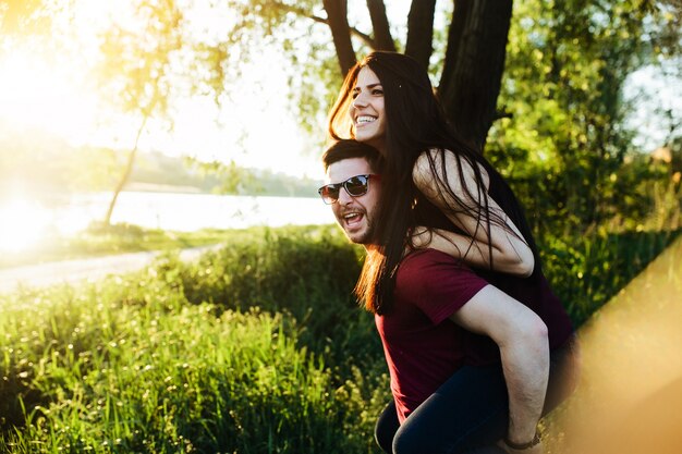 Mujer sonriendo subida en la espalda del novio