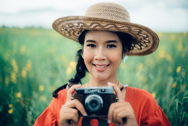 Mujer sonriendo sujetando una cámara de fotos