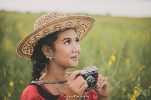 Mujer sonriendo sujetando una cámara de fotos