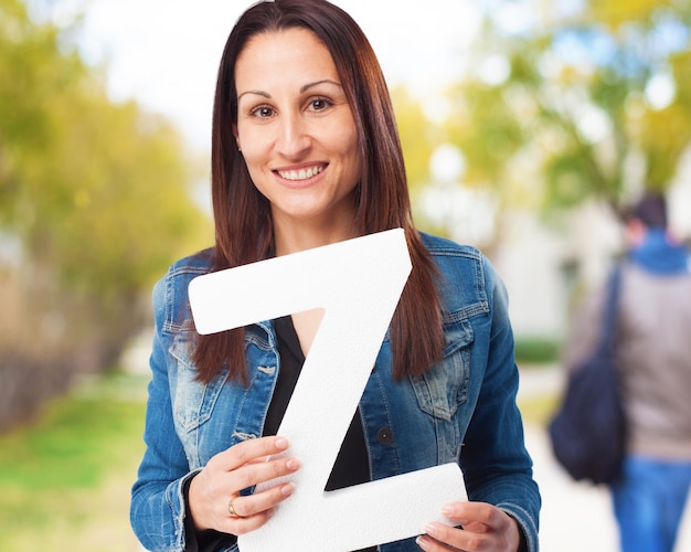 Mujer sonriendo sujetando la letra "z"