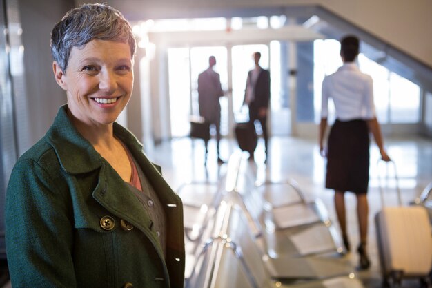 Mujer sonriendo en la terminal del aeropuerto