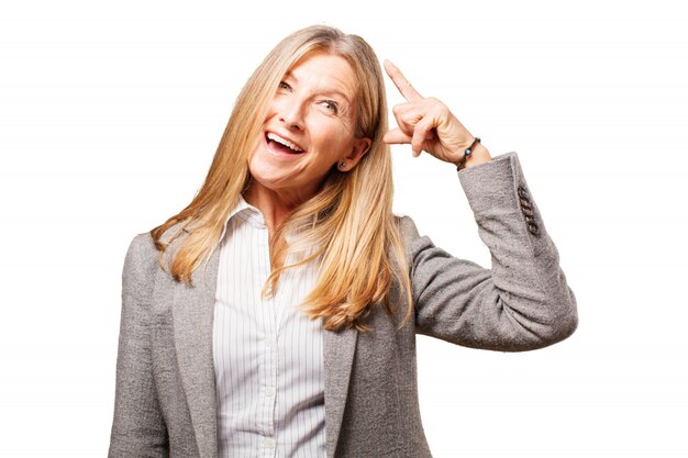 Mujer sonriendo tocándose la cabeza con un dedo