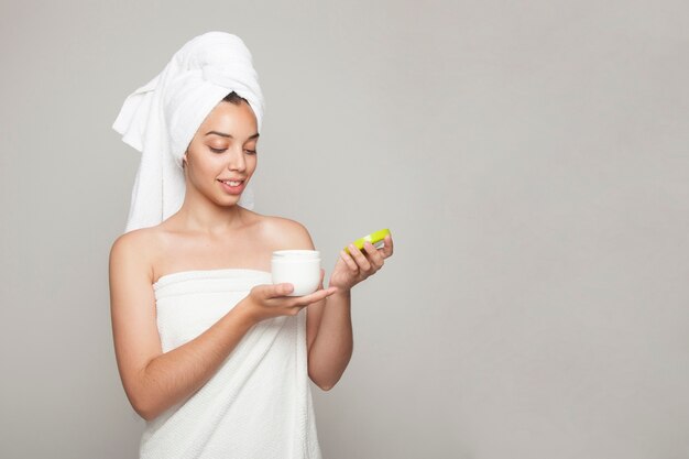 Mujer sonriente abriendo un producto cosmético