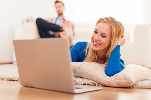 Mujer sonriente, acostado, en, sala, con, computador portatil