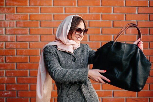 Mujer sonriente admirando su bolso