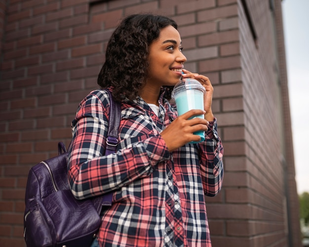 Mujer sonriente afuera con batido