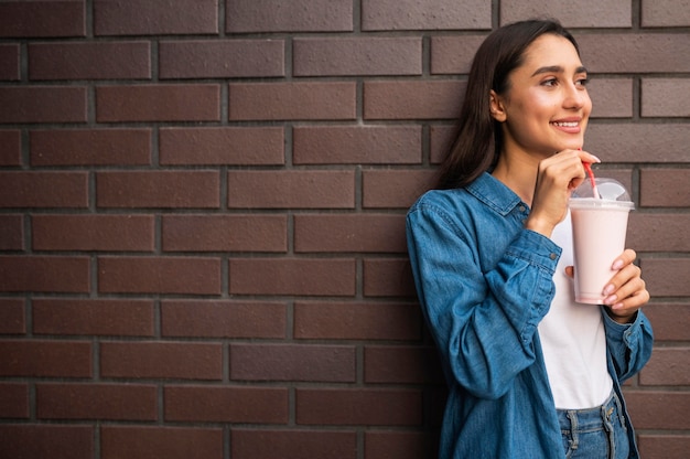 Foto gratuita mujer sonriente al aire libre con batido