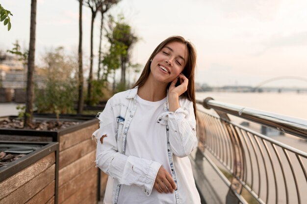 Mujer sonriente al aire libre escuchando música en los auriculares