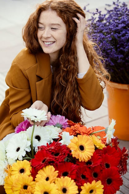 Foto gratuita mujer sonriente al aire libre en primavera con ramo de flores