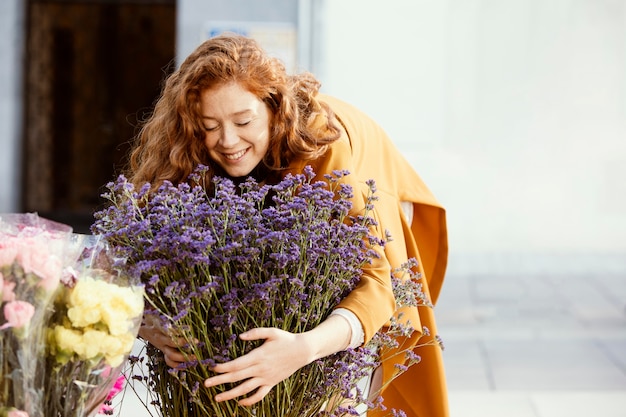 Foto gratuita mujer sonriente al aire libre con ramo de flores de primavera