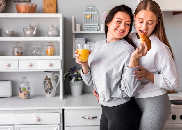 Mujer sonriente alimentando a otro mientras sostiene jugo.