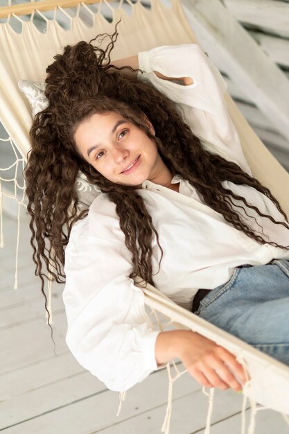 Mujer sonriente de alto ángulo acostada en la silla