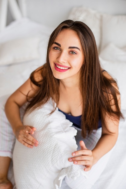 Mujer sonriente de alto ángulo con almohada