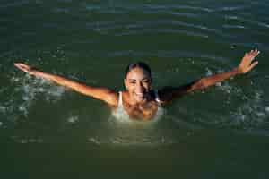 Foto gratuita mujer sonriente de alto ángulo en el lago