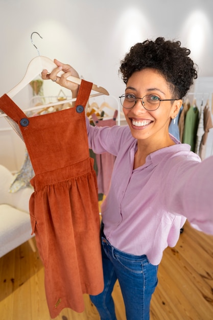 Foto gratuita mujer sonriente de alto ángulo presentando ropa