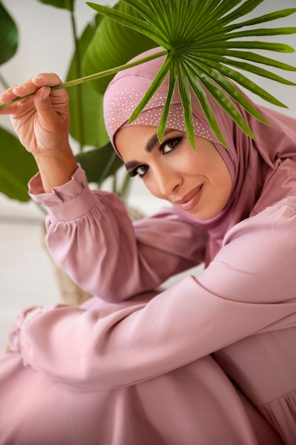 Mujer sonriente de alto ángulo sosteniendo hoja verde