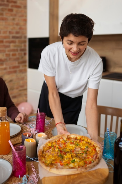 Foto gratuita mujer sonriente de alto ángulo sosteniendo pizza