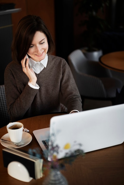 Mujer sonriente de alto ángulo con teléfono inteligente