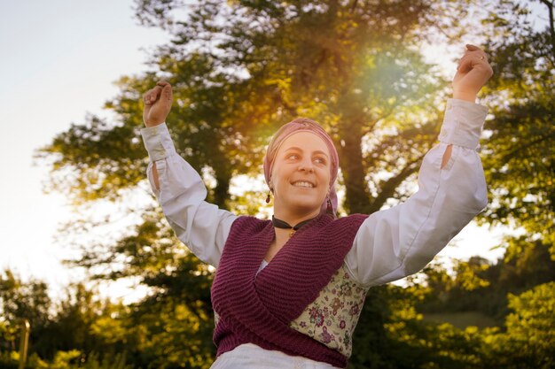 Mujer sonriente de ángulo bajo bailando al aire libre