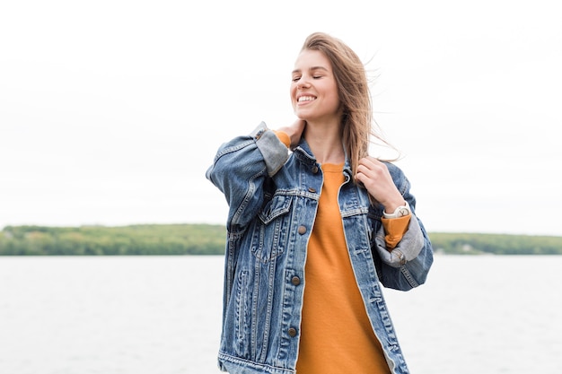 Foto gratuita mujer sonriente de ángulo bajo en la playa