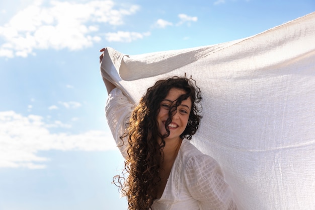 Mujer sonriente de ángulo bajo posando